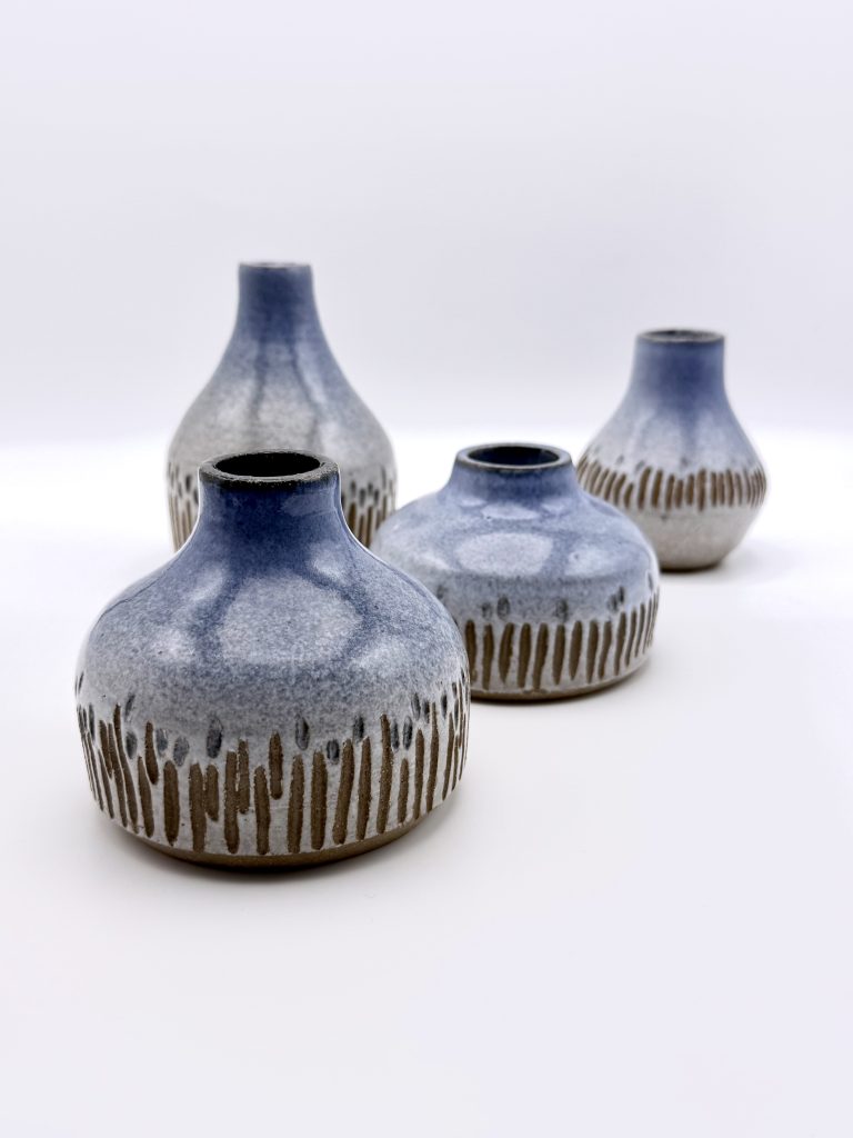 A group of 4 blue-and-white "Menorah" vases in varying shapes, on a white background.